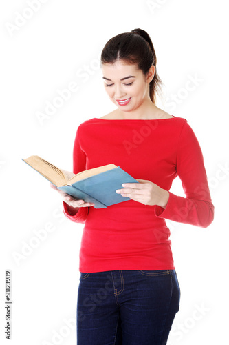 Photo: Attractive young woman holding open book,reading. Attractive young woman holding open book,reading.