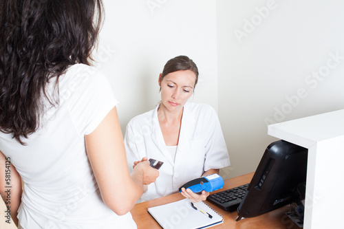 Photo: Patientin zahlt mit Kreditkarte Patientin zahlt mit Kreditkarte