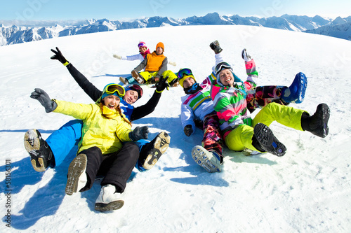 Photo: friends slide downhill together on mountain holiday friends slide downhill together on mountain holiday