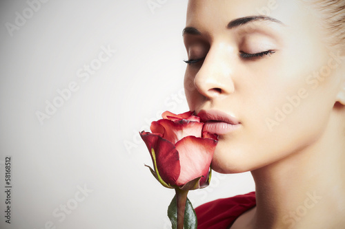 Photo: Girl and flower. beautiful woman in red dress.close-up Girl and flower. beautiful woman in red dress.close-up