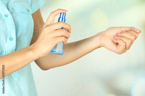Photo: Woman testing perfume on natural background Woman testing perfume on natural background