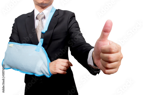 Photo: thumb up young businessman with broken hand wearing an arm brace thumb up young businessman with broken hand wearing an arm brace