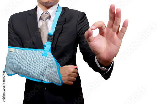 Photo: thumb up young businessman with broken hand wearing an arm brace thumb up young businessman with broken hand wearing an arm brace