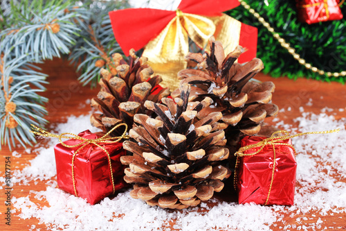 Photo: Christmas decoration with pine cones on wooden background Christmas decoration with pine cones on wooden background