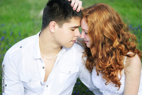 Photo: beautiful young couple in love on a green glade beautiful young couple in love on a green glade
