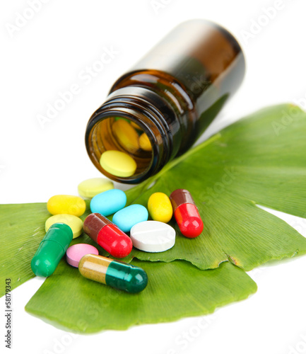 Photo: Ginkgo biloba leaves and medicine bottle with pills isolated Ginkgo biloba leaves and medicine bottle with pills isolated