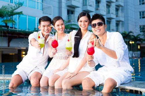 Photo: Chinese couples drinking cocktails in hotel pool bar Chinese couples drinking cocktails in hotel pool bar