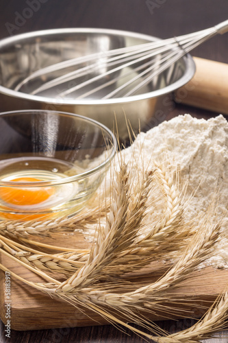 Photo: Baking ingredients with wheat ears on wood board Baking ingredients with wheat ears on wood board