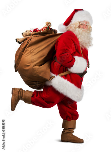 Photo: Santa Claus on the run to delivery christmas gifts isolated on w Santa Claus on the run to delivery christmas gifts isolated on w