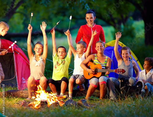 Photo: happy kids singing songs around camp fire happy kids singing songs around camp fire