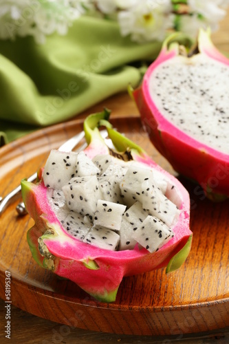 Photo: ripe sweet tropical dragon fruit on a wooden plate ripe sweet tropical dragon fruit on a wooden plate