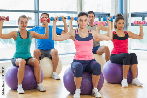 Photo: Class exercising with dumbbells on fitness balls Class exercising with dumbbells on fitness balls