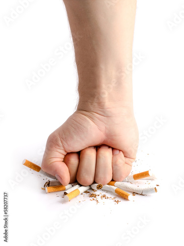 Photo: Man's fist crushing cigarettes Man's fist crushing cigarettes
