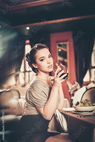 Photo: Beautiful young girl alone in a restaurant Beautiful young girl alone in a restaurant