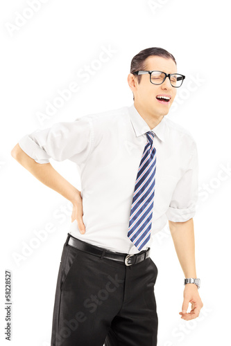 Photo: Young man with tie suffering from a back pain Young man with tie suffering from a back pain