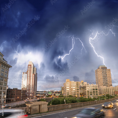 Photo: Escaping from city severe weather. Cars speeding up with lightni Escaping from city severe weather. Cars speeding up with lightni