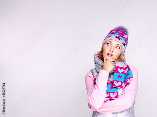 Photo: Photo of a thinking girl in winter clothes looking up Photo of a thinking girl in winter clothes looking up