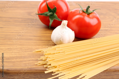 Photo: Spaghetti and tomatoes on board. Spaghetti and tomatoes on board.