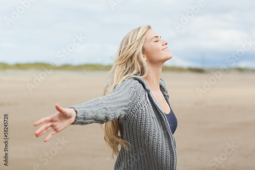 Photo: Side view of a woman stretching her arms on beach Side view of a woman stretching her arms on beach