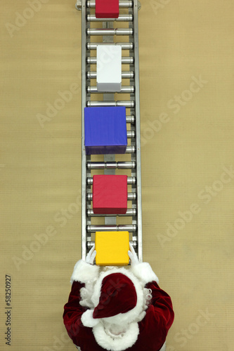 Photo: santa clause working at conveyor belt in presents factory santa clause working at conveyor belt in presents factory