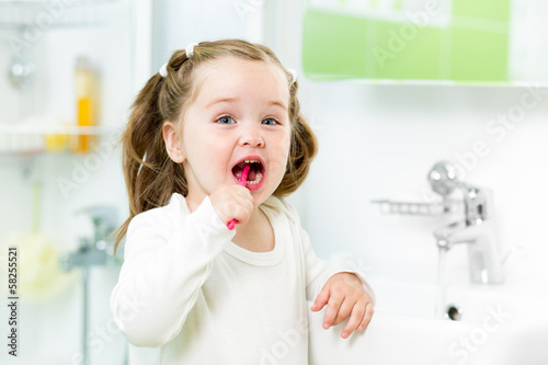 Photo: kid brushing teeth in bathroom kid brushing teeth in bathroom