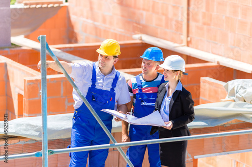 Photo: Team discussing construction or building site plans Team discussing construction or building site plans