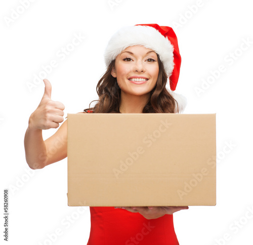Photo: smiling woman in santa helper hat with parcel box smiling woman in santa helper hat with parcel box