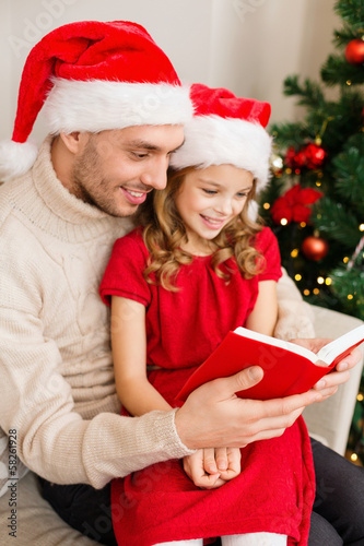 Photo: smiling father and daughter reading book smiling father and daughter reading book