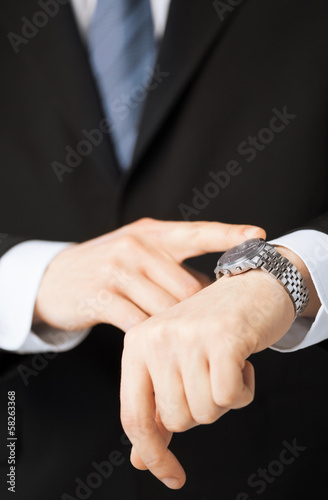 Photo: man looking at wristwatch man looking at wristwatch