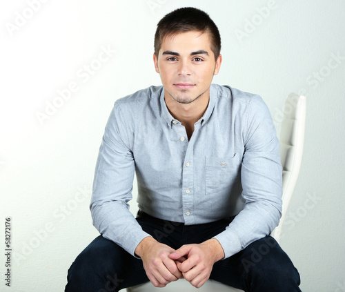 Photo: Guy sitting on chair in room Guy sitting on chair in room