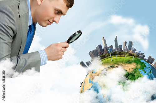 Photo: Man looking in magnifier Man looking in magnifier