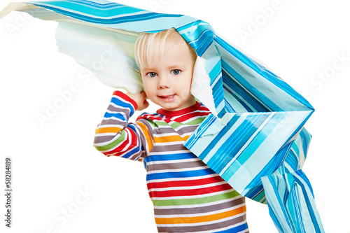 Photo: Kind spielt mit Geschenkpapier zu Weihnachten Kind spielt mit Geschenkpapier zu Weihnachten