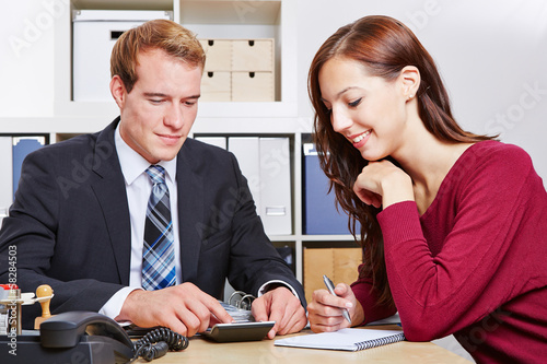 Photo: Financial consultant speaking with client in office Financial consultant speaking with client in office