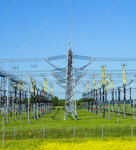 Photo: electrical power plant in colorful meadow electrical power plant in colorful meadow