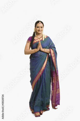 Photo: Woman making a greeting gesture and smiling Woman making a greeting gesture and smiling