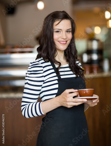 Photo: Attractive Waitress Holding Coffee Cup In Cafeteria Attractive Waitress Holding Coffee Cup In Cafeteria