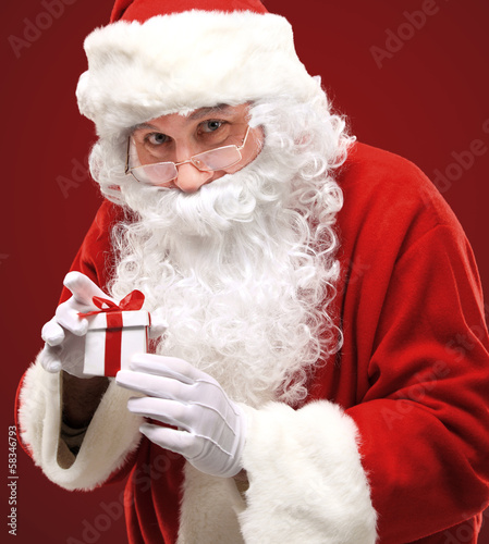 Photo: happy Santa Claus looking into white giftbox in isolation happy Santa Claus looking into white giftbox in isolation