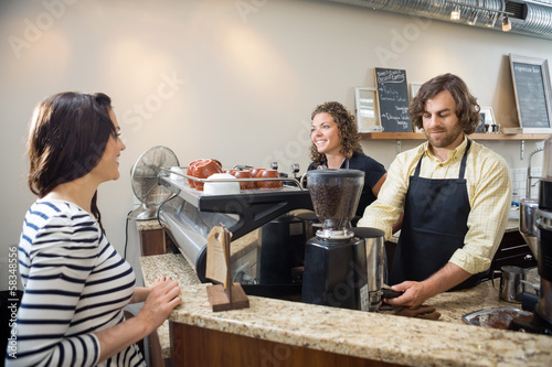 Photo: Customer Looking At Baristas Making Coffee In Cafeteria Customer Looking At Baristas Making Coffee In Cafeteria