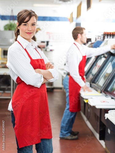 Photo: Female Butcher Standing Arms Crossed At Store Female Butcher Standing Arms Crossed At Store