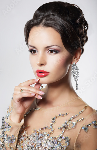 Photo: Portrait of elegant woman with evening hairstyle and earrings. Portrait of elegant woman with evening hairstyle and earrings.