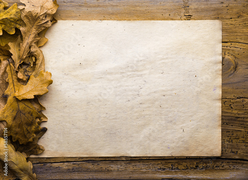 Photo: leaves and paper on wooden background leaves and paper on wooden background