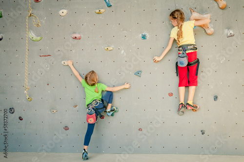 Photo: two little girls climbing a rock wall two little girls climbing a rock wall