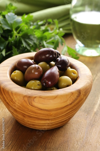 Photo: marinated green and black olives (Kalamata) in a wooden bowl marinated green and black olives (Kalamata) in a wooden bowl