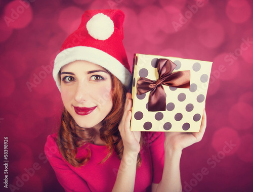 Photo: Redhead girl with gifts on red background Redhead girl with gifts on red background