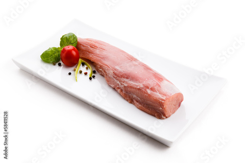 Photo: Raw pork loin and vegetables on white background Raw pork loin and vegetables on white background