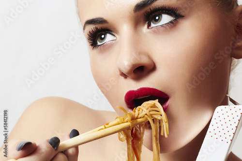 Photo: beautiful woman eating chinese food. wok. noodles beautiful woman eating chinese food. wok. noodles