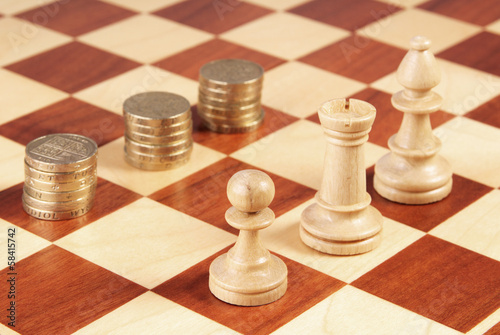 Photo: Chess board with coins and chess pieces Chess board with coins and chess pieces