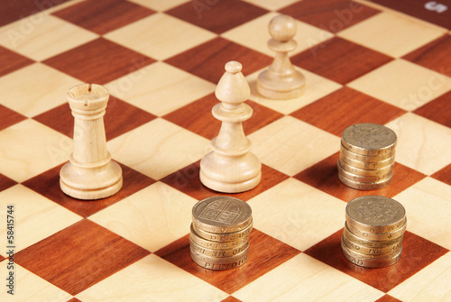 Photo: Chess board with coins and chess pieces Chess board with coins and chess pieces