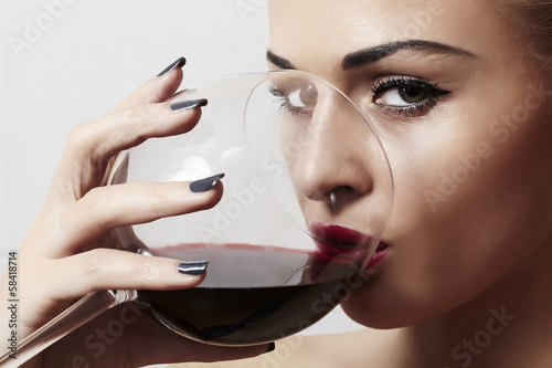 Photo: Beautiful blond woman drinking red wine.make-up.red lips Beautiful blond woman drinking red wine.make-up.red lips