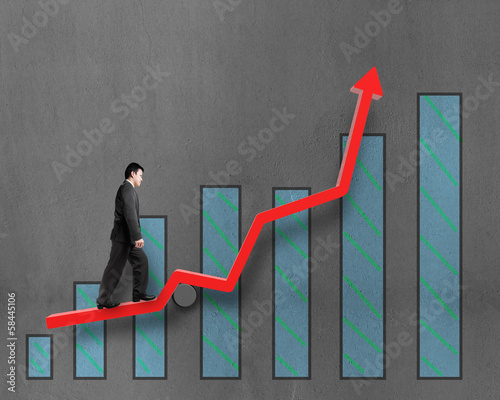 Photo: Businessman walking on growth red arrow with chart Businessman walking on growth red arrow with chart